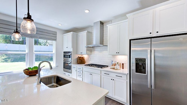 kitchen featuring white cabinets, wall chimney exhaust hood, sink, and stainless steel appliances