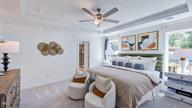 carpeted bedroom featuring a tray ceiling, multiple windows, ornamental molding, and ceiling fan