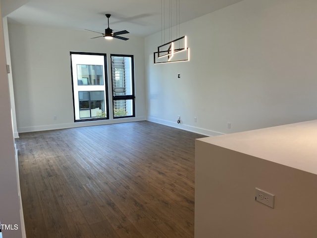 empty room featuring ceiling fan and dark wood-type flooring