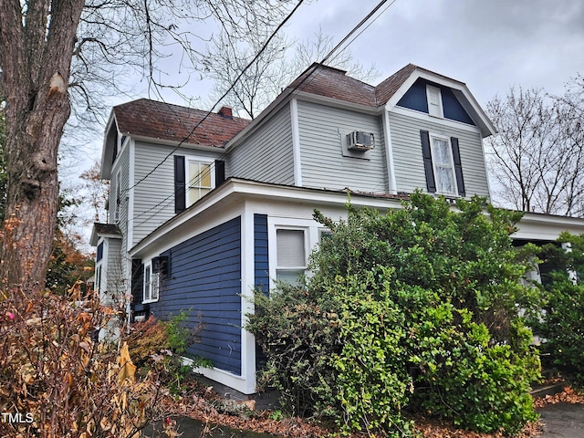 view of side of property with an AC wall unit