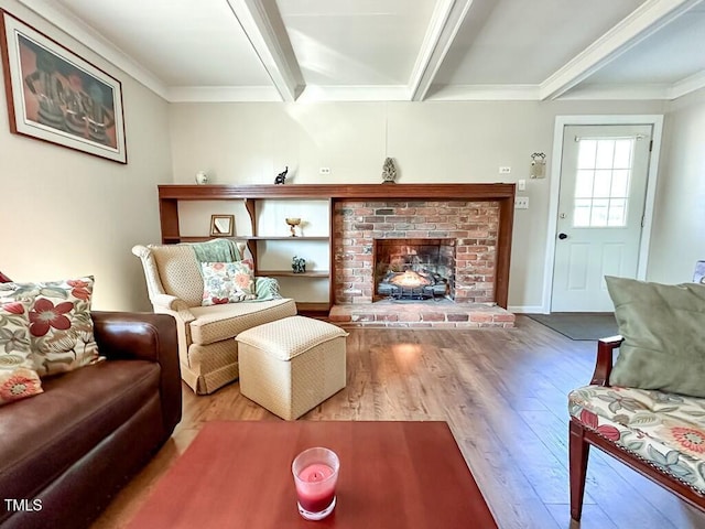 living room featuring a fireplace, wood-type flooring, ornamental molding, and beamed ceiling