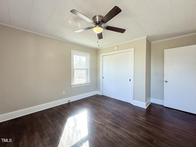 unfurnished bedroom with a closet, dark wood-type flooring, ceiling fan, and crown molding