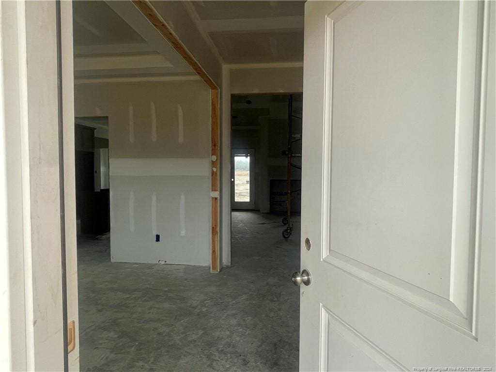 corridor featuring concrete flooring and electric panel