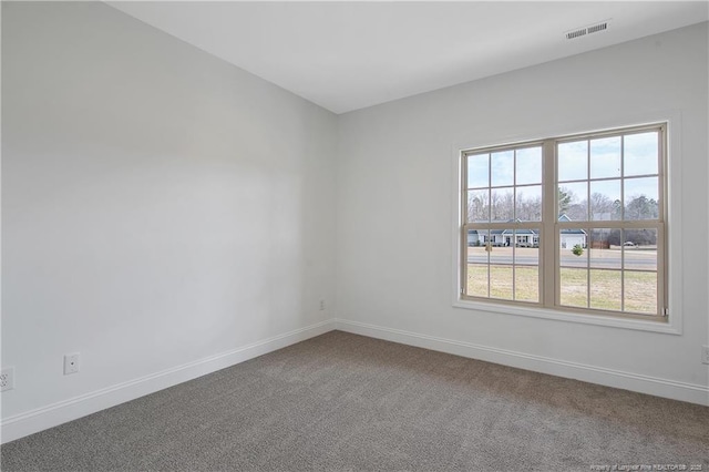 carpeted empty room featuring baseboards and visible vents