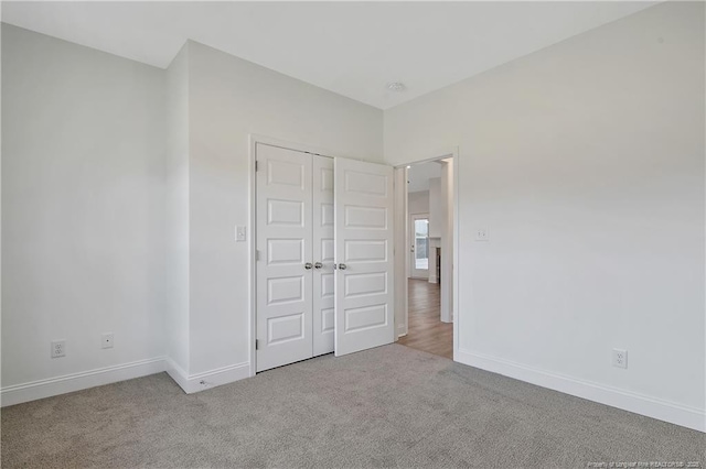 unfurnished bedroom featuring a closet, baseboards, and carpet flooring