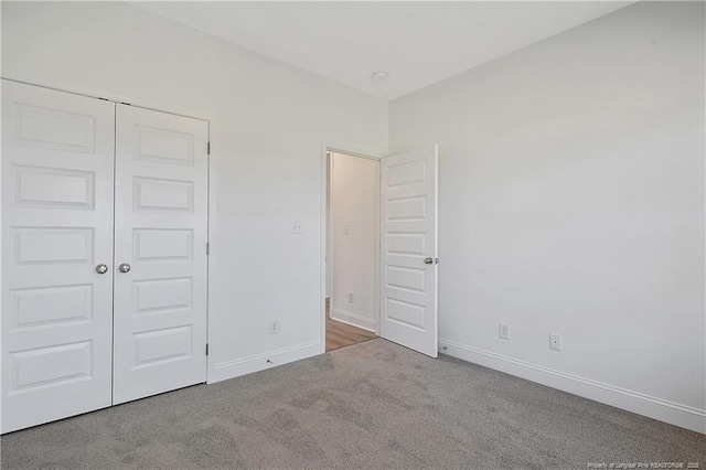 unfurnished bedroom featuring carpet, a closet, and baseboards