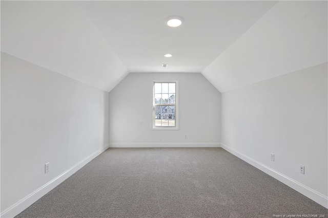 additional living space with lofted ceiling, carpet floors, and baseboards