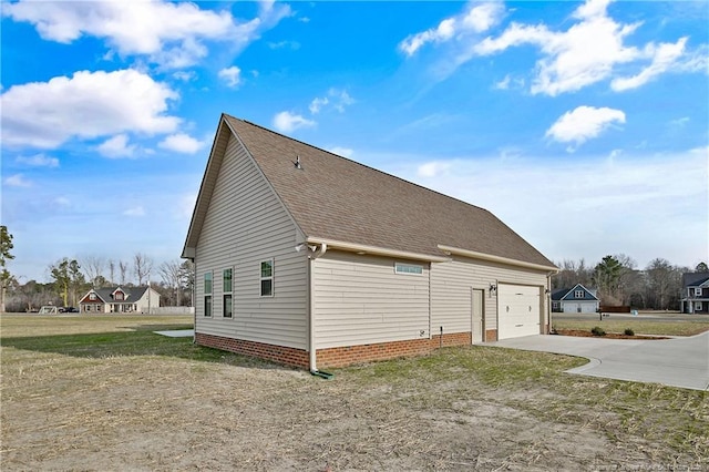 view of home's exterior featuring driveway, a garage, and roof with shingles