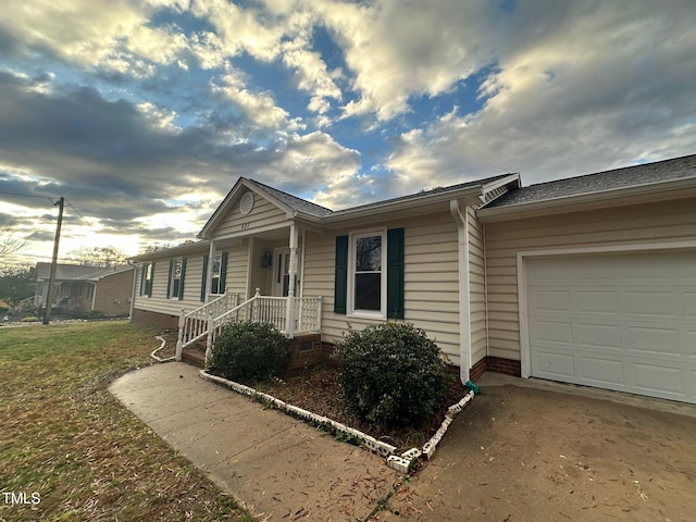 ranch-style home with a garage and a front lawn