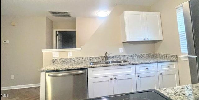 kitchen featuring light stone countertops, sink, stainless steel dishwasher, and white cabinets