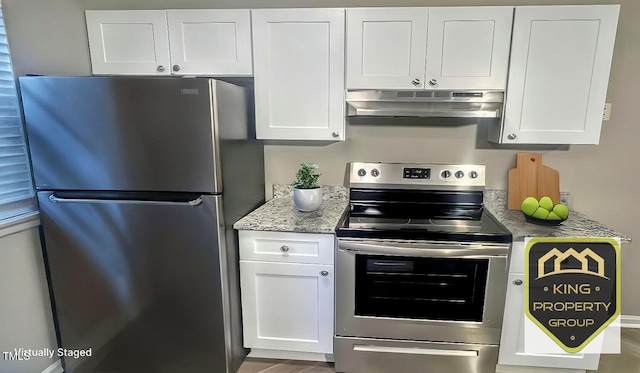 kitchen with light stone counters, stainless steel appliances, and white cabinets