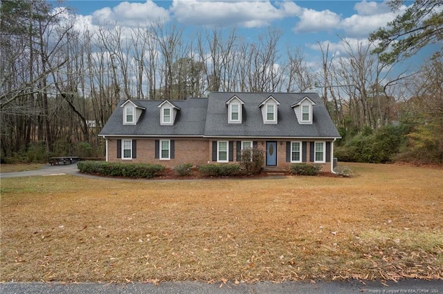 cape cod-style house with a front lawn