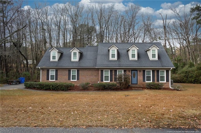 cape cod home with a front lawn