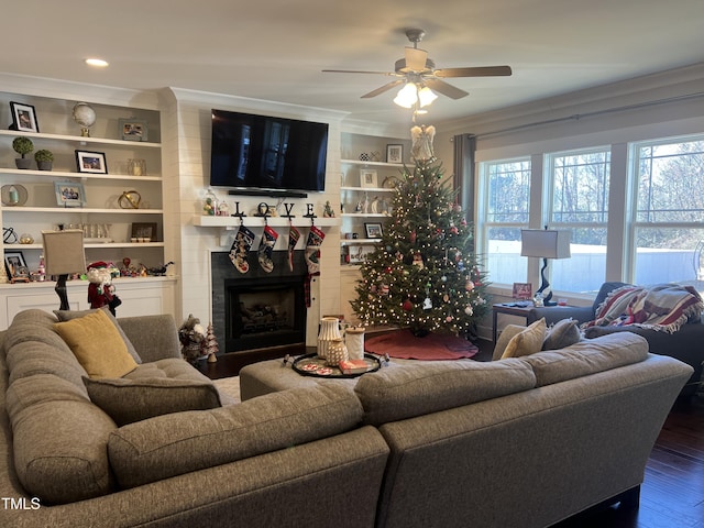 living room with hardwood / wood-style flooring, ceiling fan, ornamental molding, and built in shelves