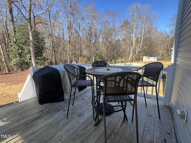 wooden terrace with grilling area and a shed