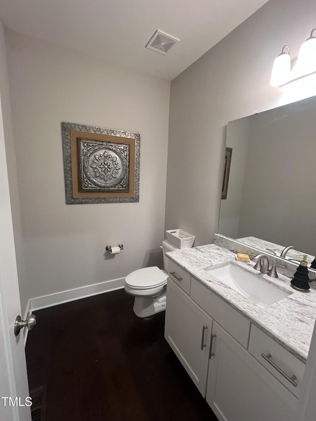 bathroom featuring vanity, toilet, and wood-type flooring