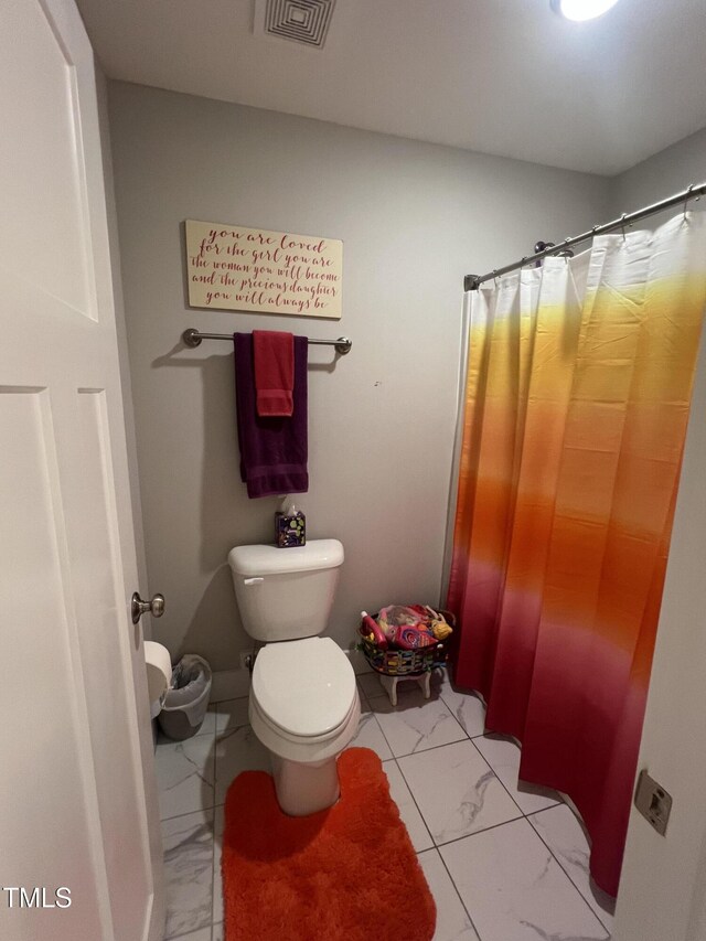 bathroom featuring walk in shower and toilet