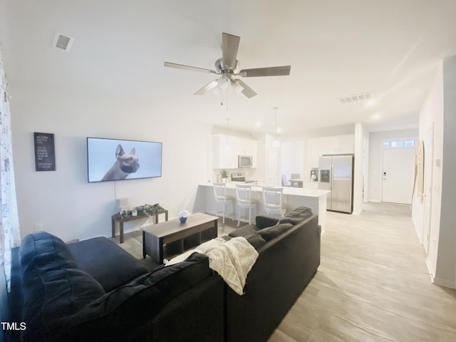 living room featuring ceiling fan and light hardwood / wood-style flooring