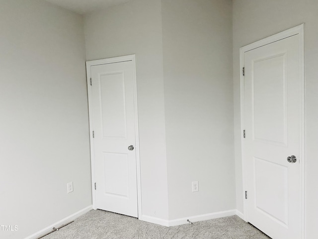 unfurnished room featuring light colored carpet