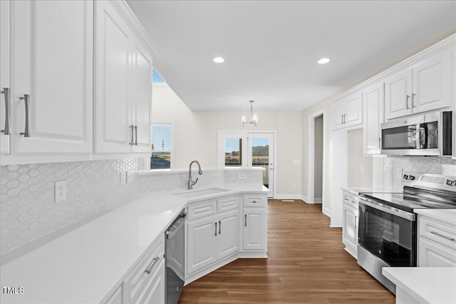 kitchen with dark hardwood / wood-style flooring, white cabinetry, sink, and appliances with stainless steel finishes