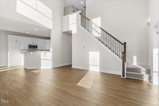 unfurnished living room with dark hardwood / wood-style flooring and a high ceiling