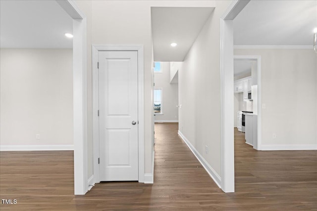 hall with dark hardwood / wood-style floors and crown molding