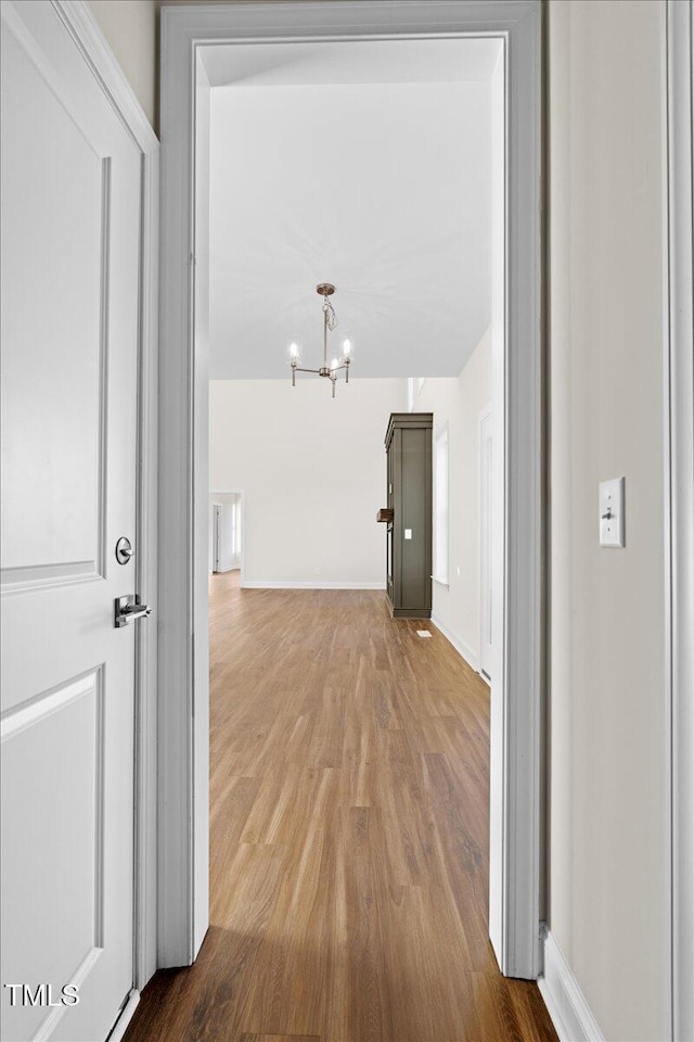 hall featuring a chandelier and hardwood / wood-style flooring