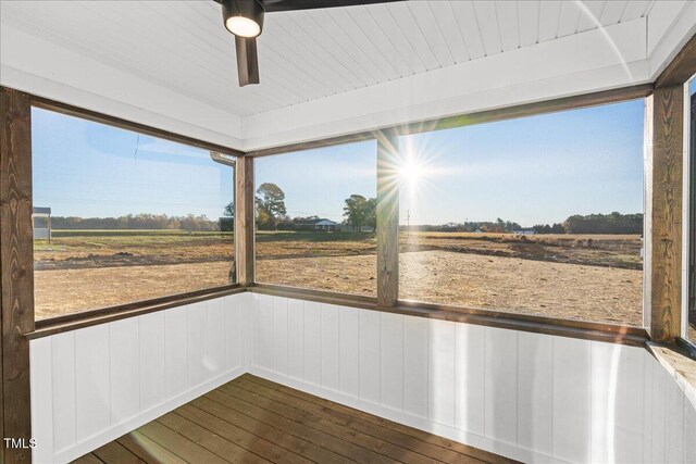 unfurnished sunroom featuring plenty of natural light and a rural view