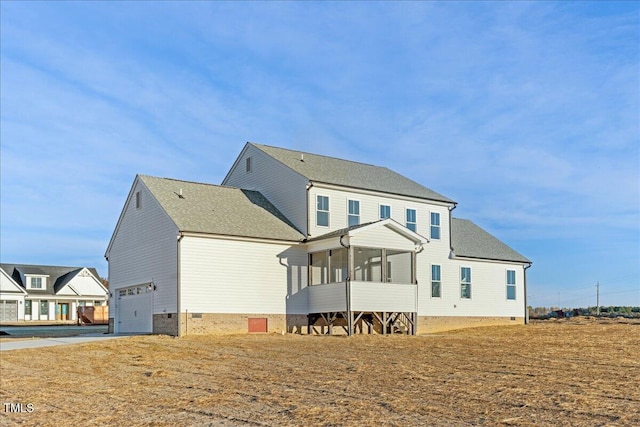 rear view of property featuring a sunroom and a garage