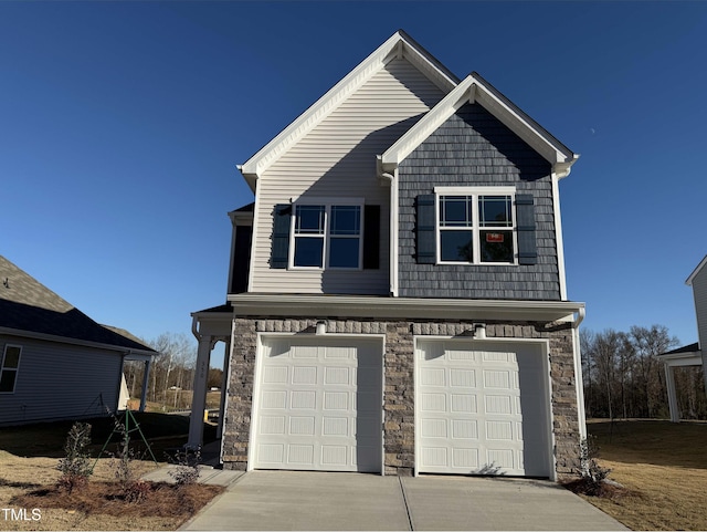 craftsman-style house with a garage, driveway, and stone siding