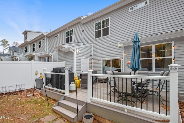 back of property with a wooden deck and central AC