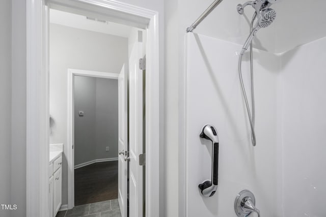 bathroom featuring tile patterned flooring, vanity, and walk in shower