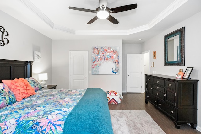 bedroom with ceiling fan, a raised ceiling, ornamental molding, and dark wood-type flooring