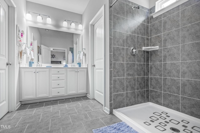 bathroom featuring a tile shower and vanity