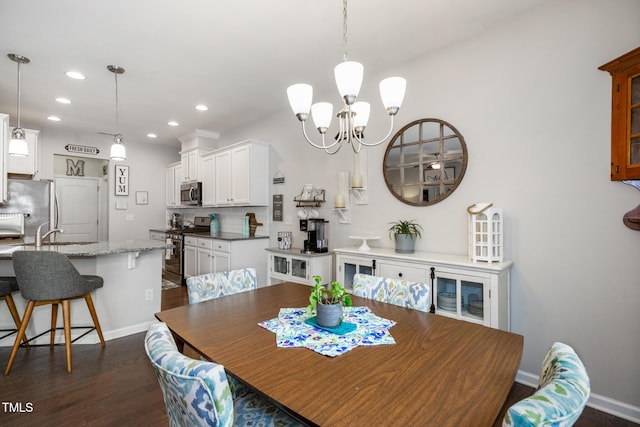 dining space featuring a chandelier, dark hardwood / wood-style floors, and sink