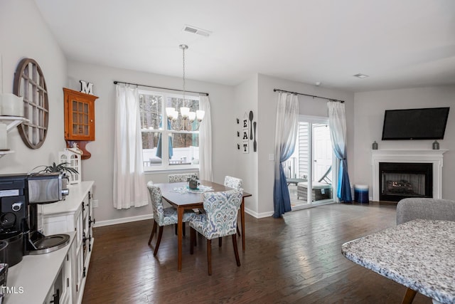 dining area with dark wood-type flooring and a chandelier