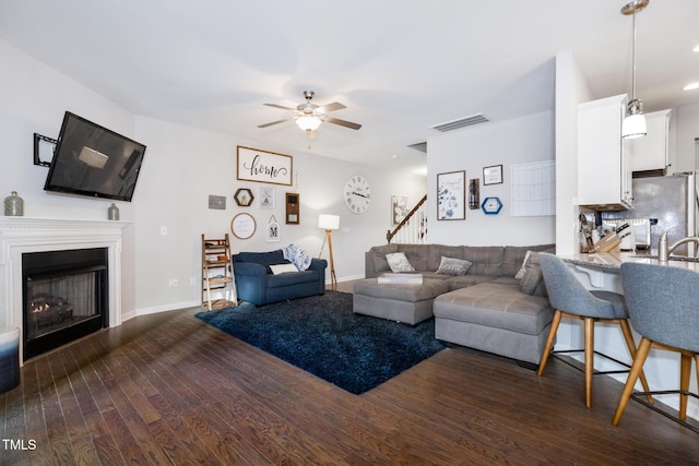 living room with dark hardwood / wood-style floors and ceiling fan