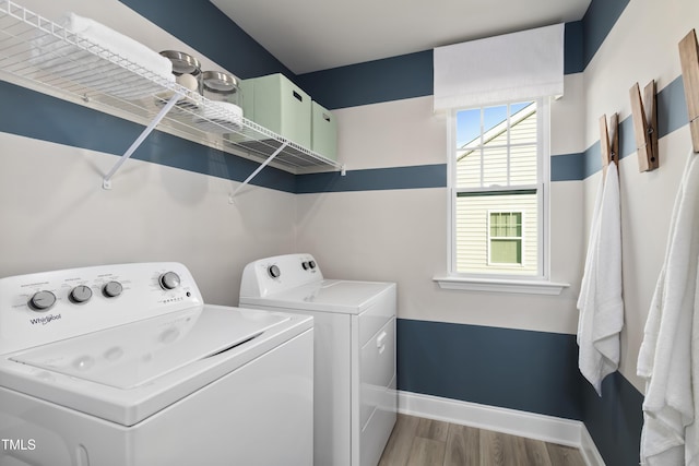 laundry area with washer and dryer and light hardwood / wood-style floors