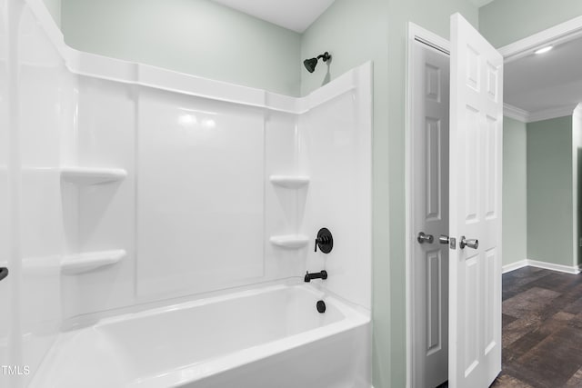 bathroom featuring hardwood / wood-style floors, ornamental molding, and washtub / shower combination