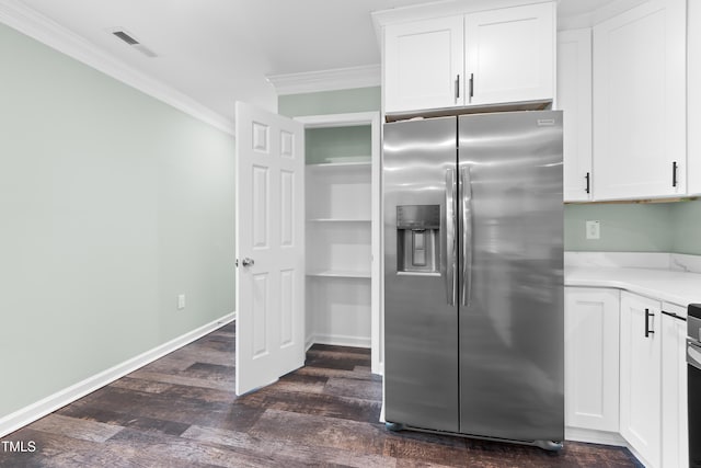 kitchen with dark hardwood / wood-style floors, stainless steel fridge, white cabinetry, and ornamental molding