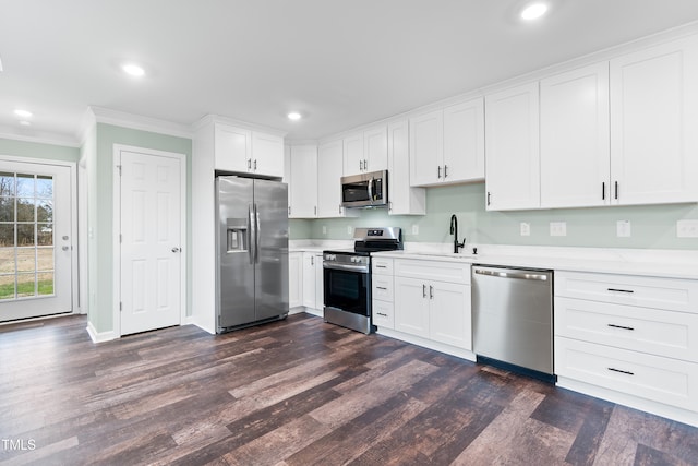 kitchen with stainless steel appliances, white cabinetry, dark hardwood / wood-style floors, and sink