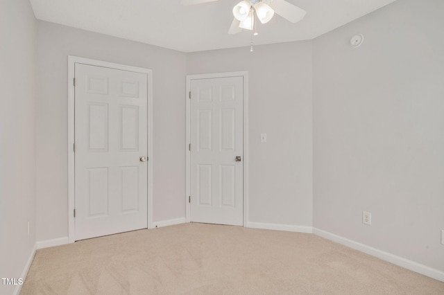 unfurnished bedroom with ceiling fan and light colored carpet