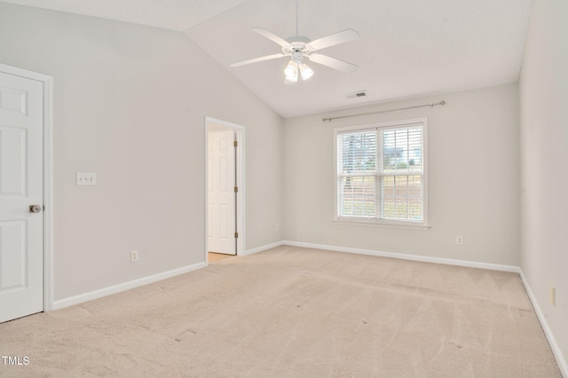 carpeted empty room with ceiling fan and lofted ceiling