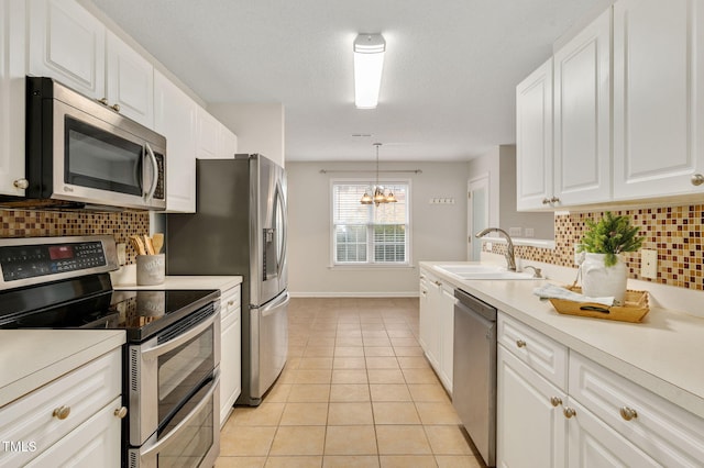 kitchen with white cabinetry, sink, stainless steel appliances, an inviting chandelier, and tasteful backsplash