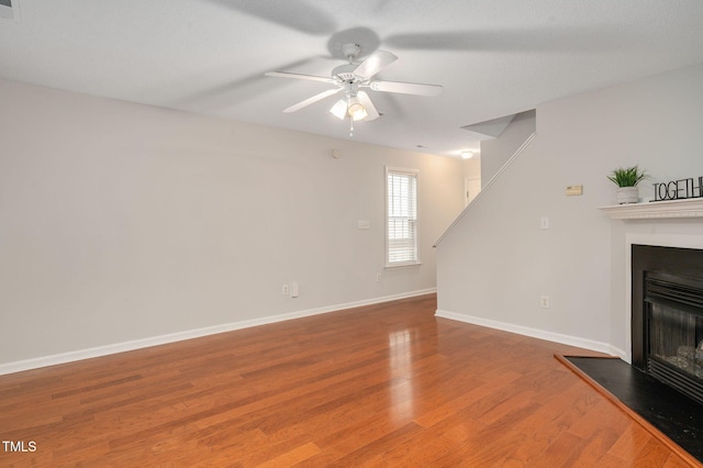 unfurnished living room with ceiling fan and hardwood / wood-style flooring