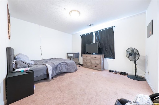 bedroom featuring a textured ceiling and light colored carpet