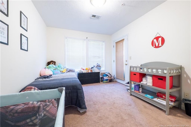 bedroom with carpet floors and a textured ceiling