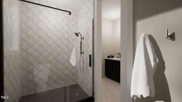 bathroom with a tile shower, vanity, and wood-type flooring