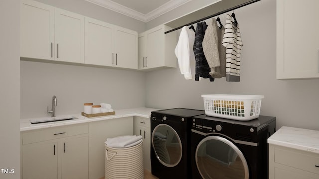 laundry area featuring cabinets, separate washer and dryer, crown molding, and sink