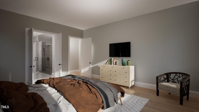 bedroom featuring ensuite bathroom and light hardwood / wood-style floors